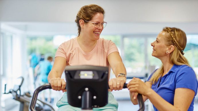 Frau auf Ergometer bei Geräteeinweisung