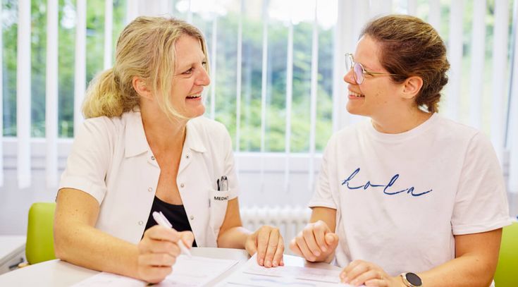 Eine Diabetesberaterin und eine Patientin sitzen am Tisch und besprechen die Diabetestherapie