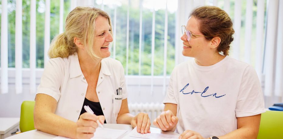 Eine Diabetesberaterin und eine Patientin sitzen am Tisch und besprechen die Diabetestherapie