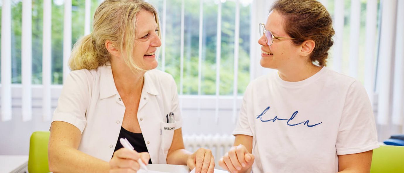 Eine Diabetesberaterin und eine Patientin sitzen am Tisch und besprechen die Diabetestherapie