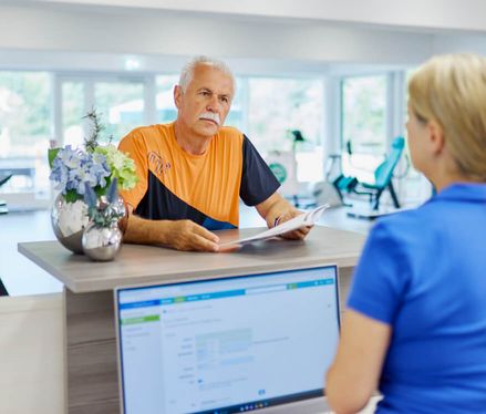 Patient an der Theke im Sportpark Reha nach Prostatakrebs