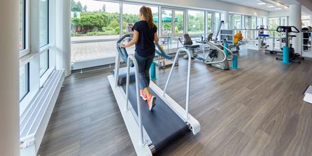 Im Sportpark trainiert eine Frau auf dem Laufband