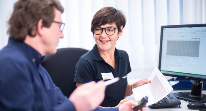 Gespräch Eine Mitarbeiterin und ein Patient sind im Gespräch