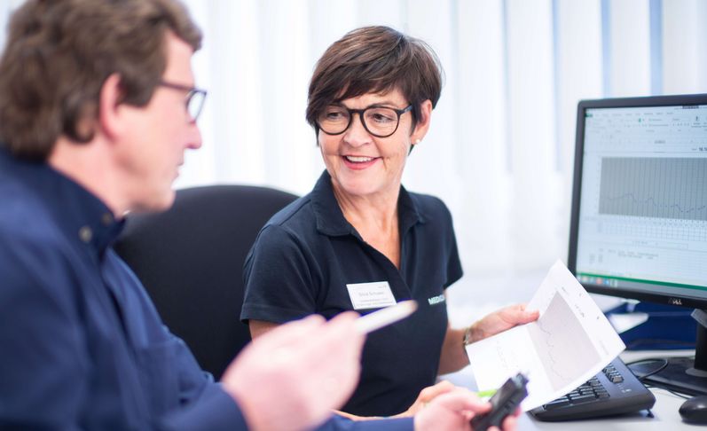 Eine Mitarbeiterin und ein Patient sind im Gespräch 