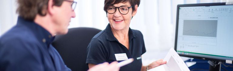 Eine Mitarbeiterin und ein Patient sind im Gespräch 