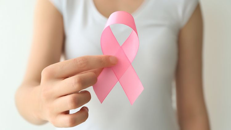 Frau hält eine rosa Schleife in der Hand