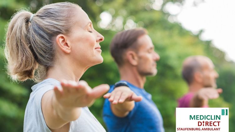 Eine Gruppe aus Frauen und Männern macht Yoga 