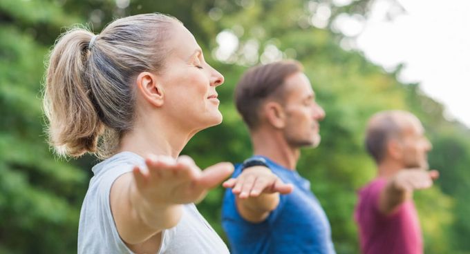 Krankheitsbilder A bis Z Mehrere Menschen machen Yoga in der Gruppe