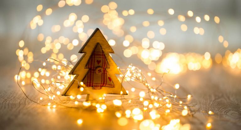 Weihnachtsbaum aus Holz mit Lichterkette auf einem Holztisch