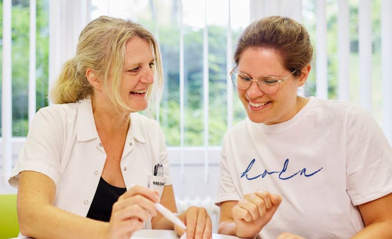 Eine Diabetesberaterin und eine Patientin sitzen am Tisch und besprechen die Diabetestherapie